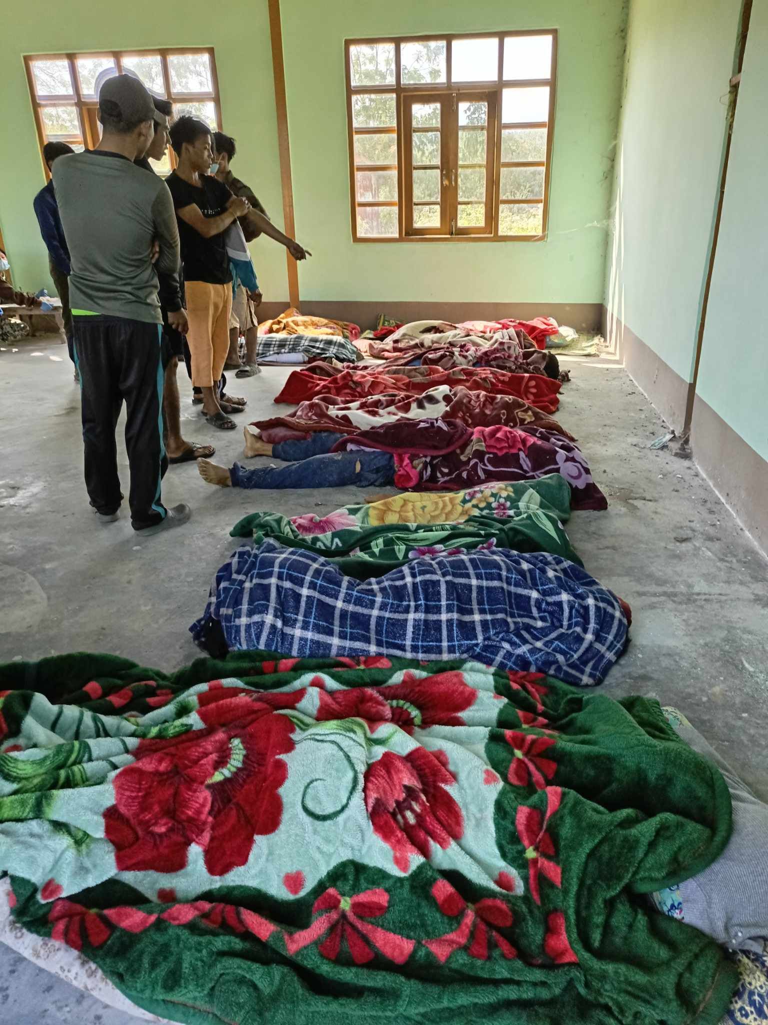Responders collect the bodies of airstrike victims in Khampat, 7 January 2023. (Photo: Chindwin News Agency)