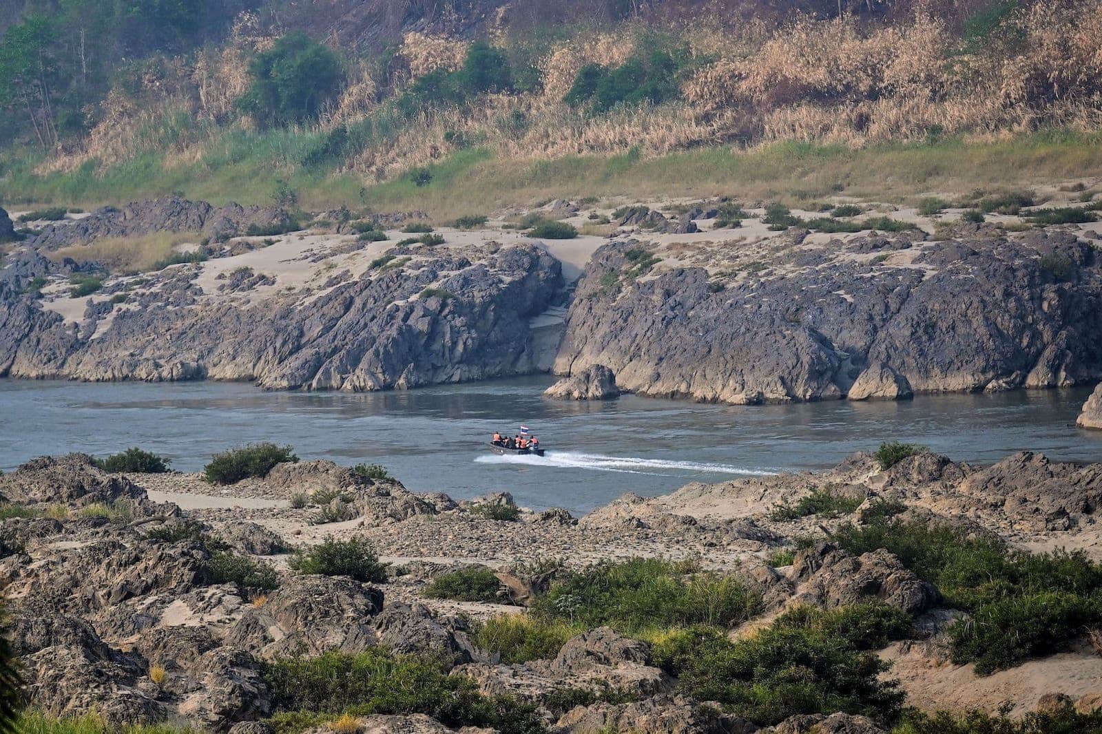 A boat flying the Thai flag patrols the Salween river following SAC airstrikes on villages in Karen State in March 2021.